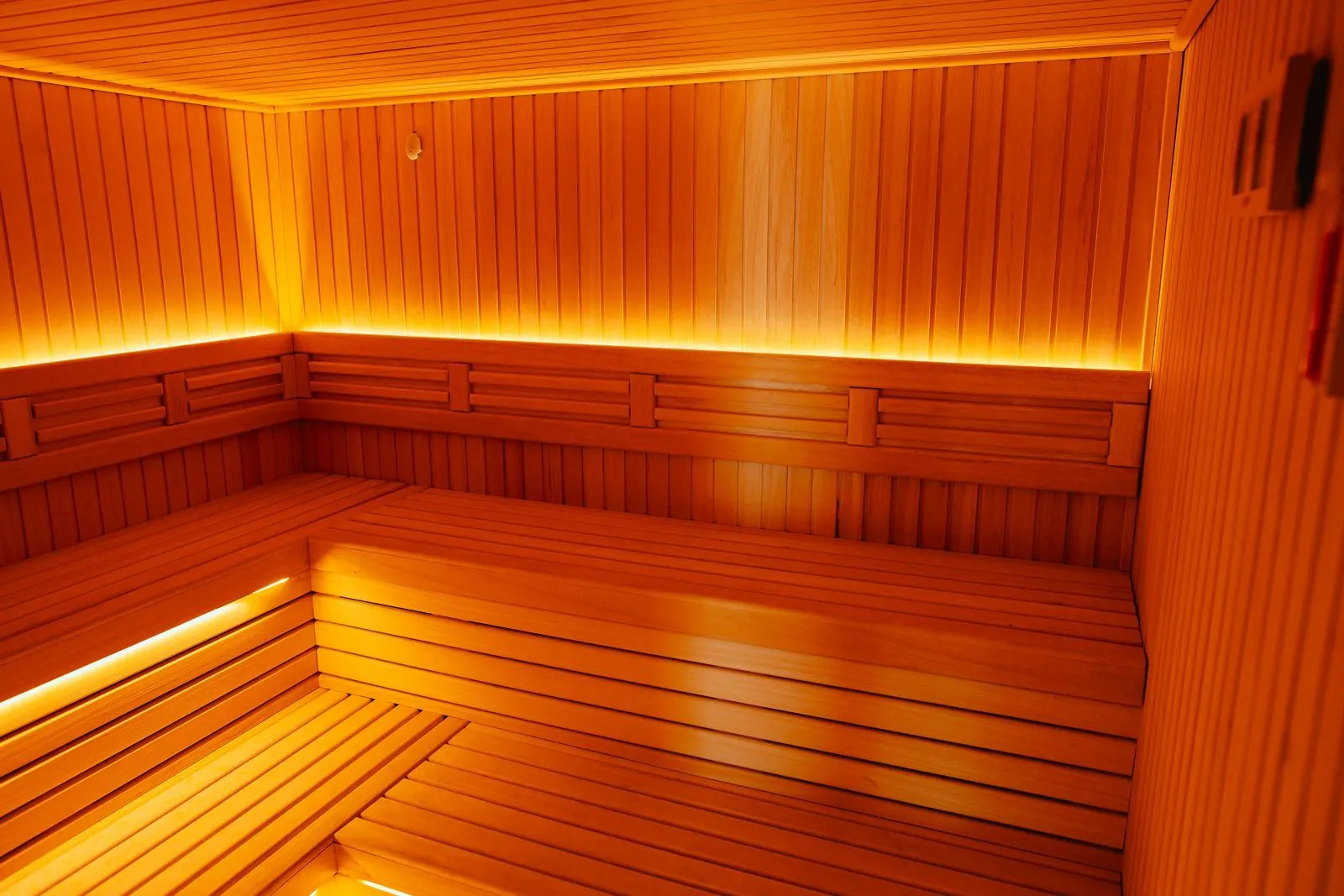 Sauna sa drvenim klupama i toplim svetlom